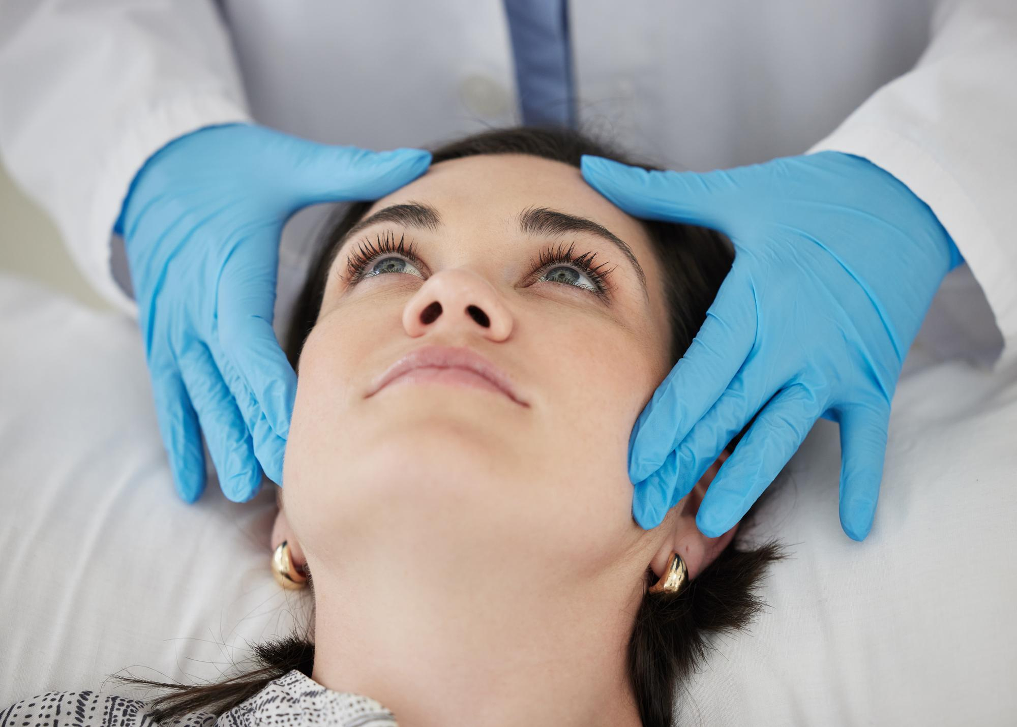 A doctor examines the patient's features prior to recommending a treatment for facial rejuvenation in Bethesda.