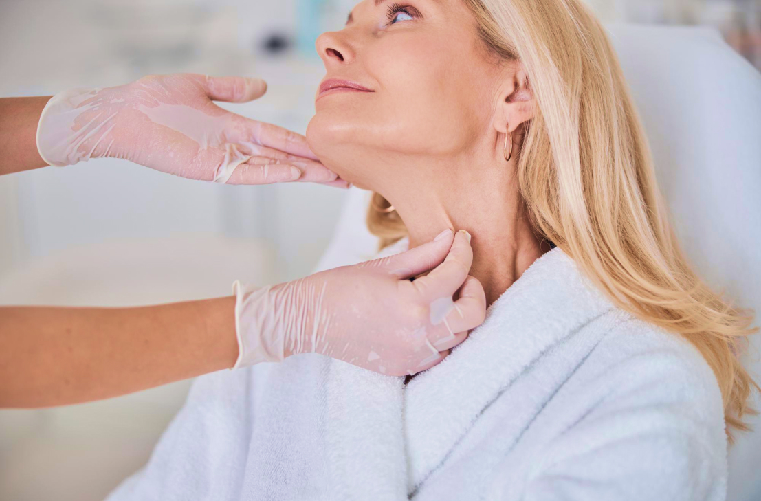 A provider examines a patient's neck skin to confirm if she is eligible for treatment with Morpheus8 in Bethesda.