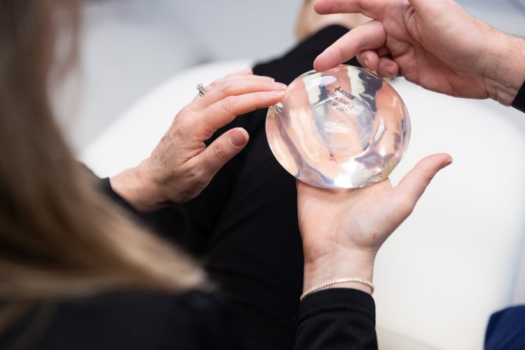 A patient holds a breast implant during her consultation for plastic surgery near Bethesda, MD.