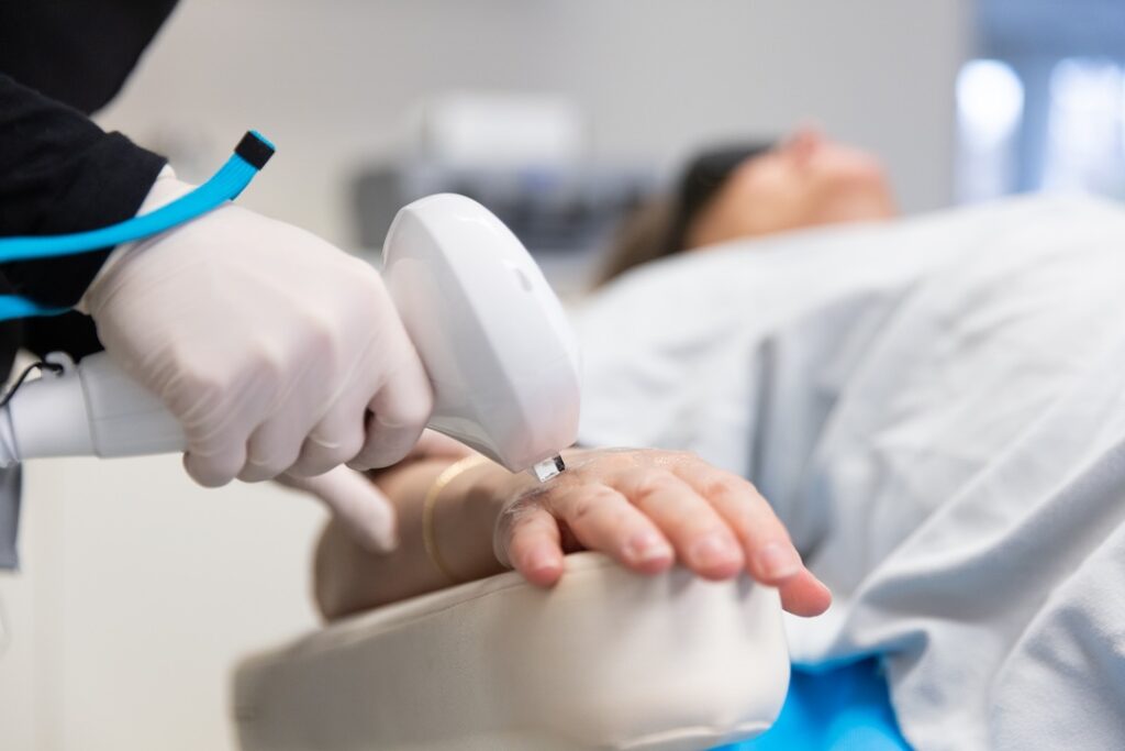 Dr. Faulkner glides the Lumecca IPL device across a patient's skin as a hyperpigmentation near Bethesda, MD.